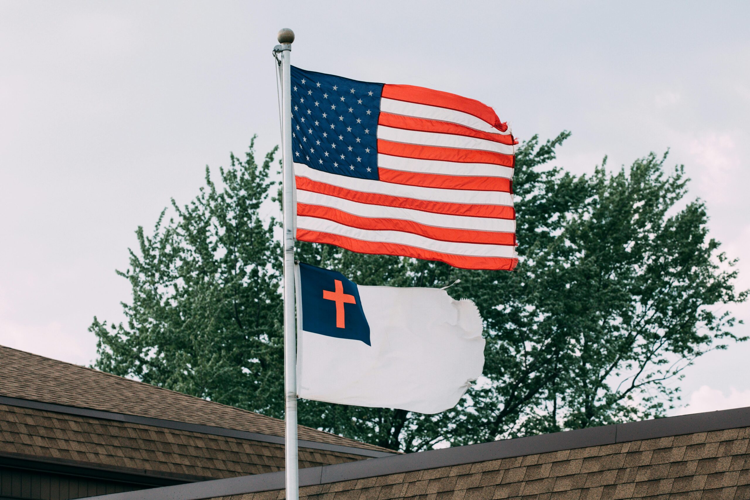 Patriotic display of American and Christian flags on rooftop in Springfield, IL.